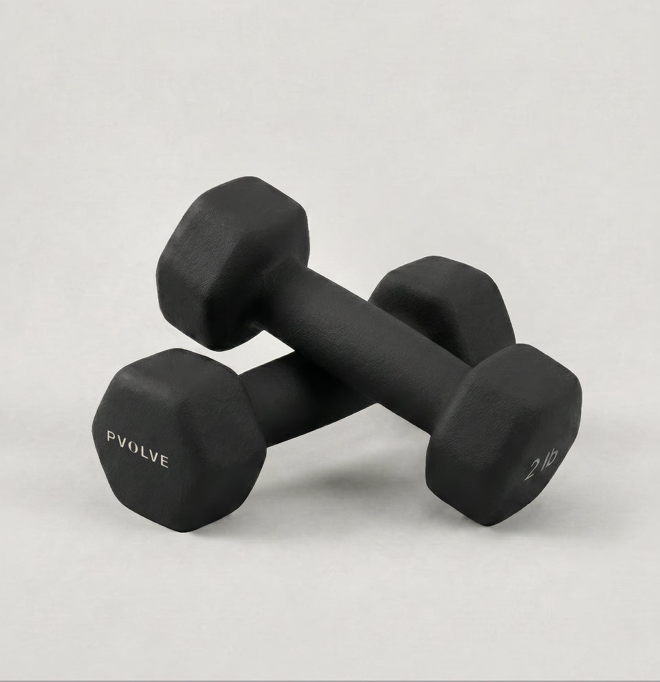 A pair of black, hexagonal 2 lb dumbbells from Pvolve on a light background.