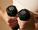 Trainer hands holding 2 lb. hand weights together showing logos thumbnail