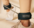 Trainer wearing heavy ankle bands with Pvolve logo